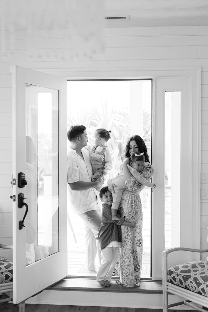 Candid in-home family photo with parents and three siblings during a relaxed lifestyle session in Port Saint Lucie