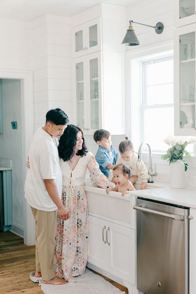 Candid in-home family photo with parents and three siblings during a relaxed lifestyle session in Port Saint Lucie
