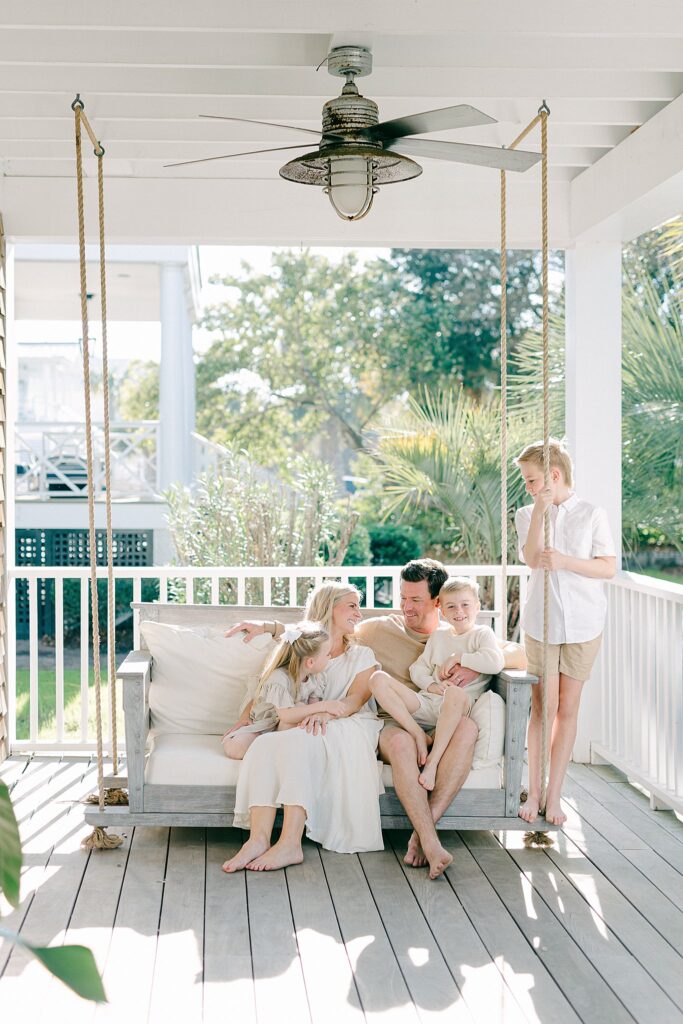 Fun and playful family moment captured on a shaded porch, showcasing stress-free family photography near Stuart, Florida.
