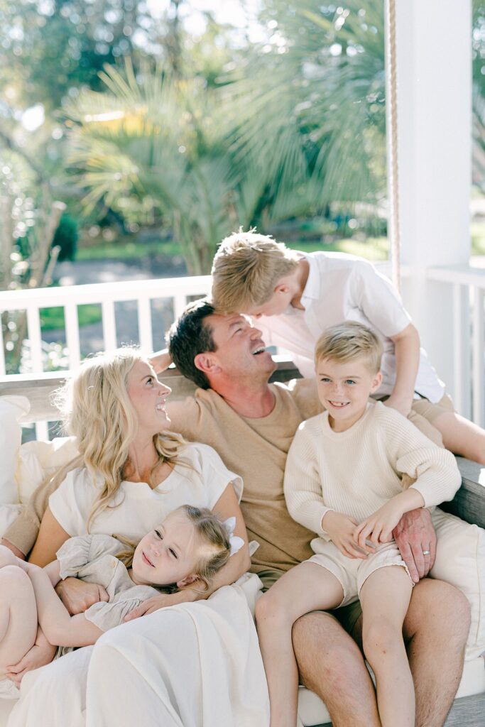 Family enjoying a peaceful moment on their front porch swing, documented by a full-service family photographer in Tequesta, Florida.