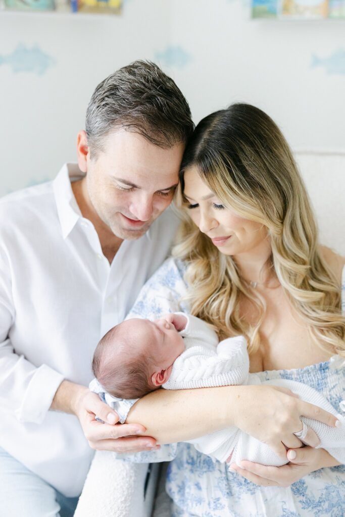 Heartfelt moment between new parents and their baby — lifestyle newborn session by a luxury family photographer serving Jupiter and surrounding areas.