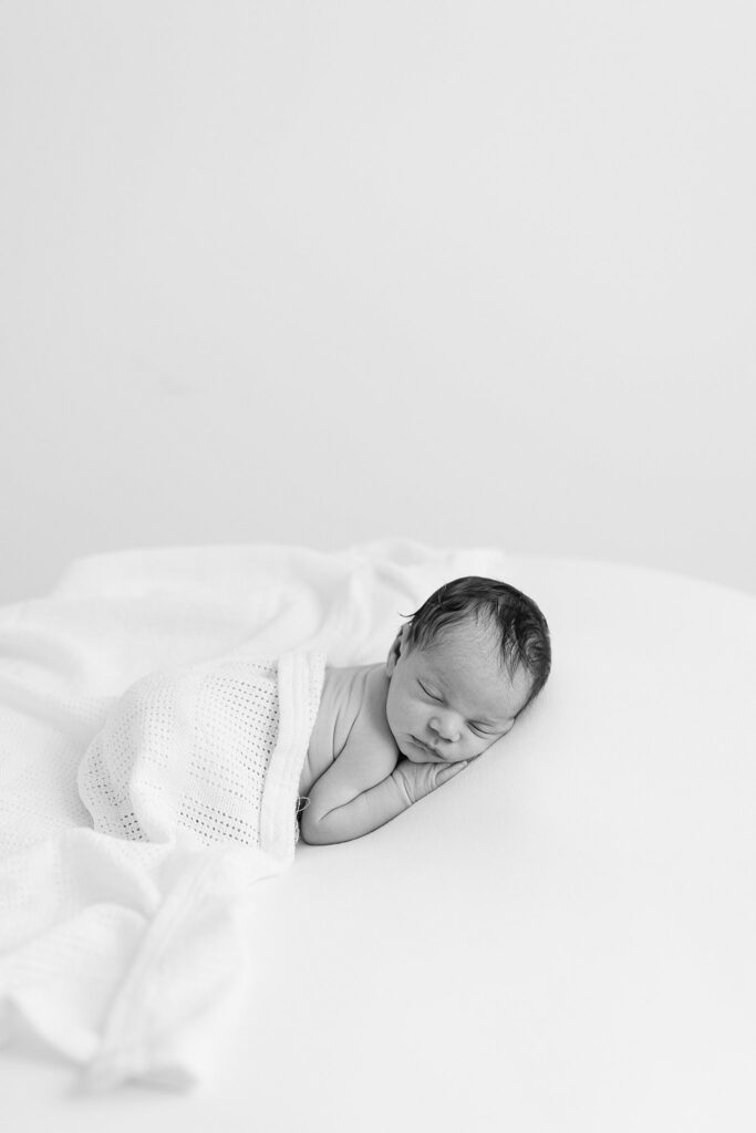 Peaceful newborn wrapped in a soft swaddle during a studio session in Port Saint Lucie — stress-free newborn portraits designed for heirloom keepsakes.
