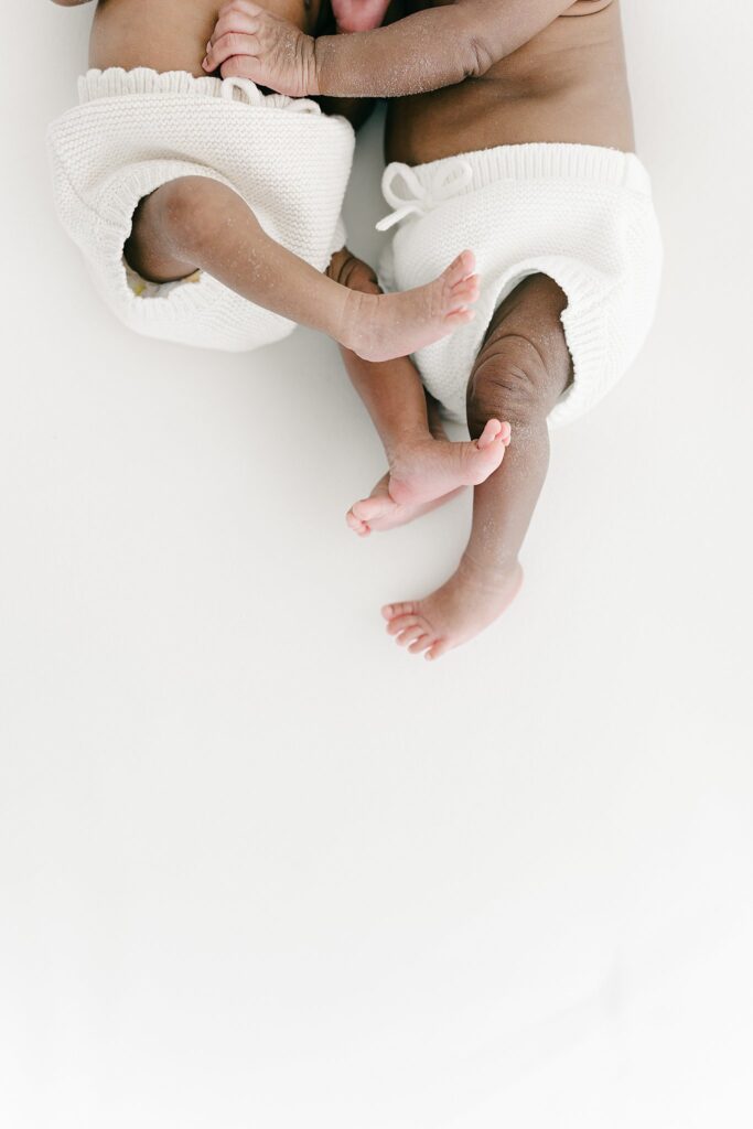 Artistic close-up of twin newborns lying together — photographed during a full-service newborn session in Palm Beach Gardens, Florida.