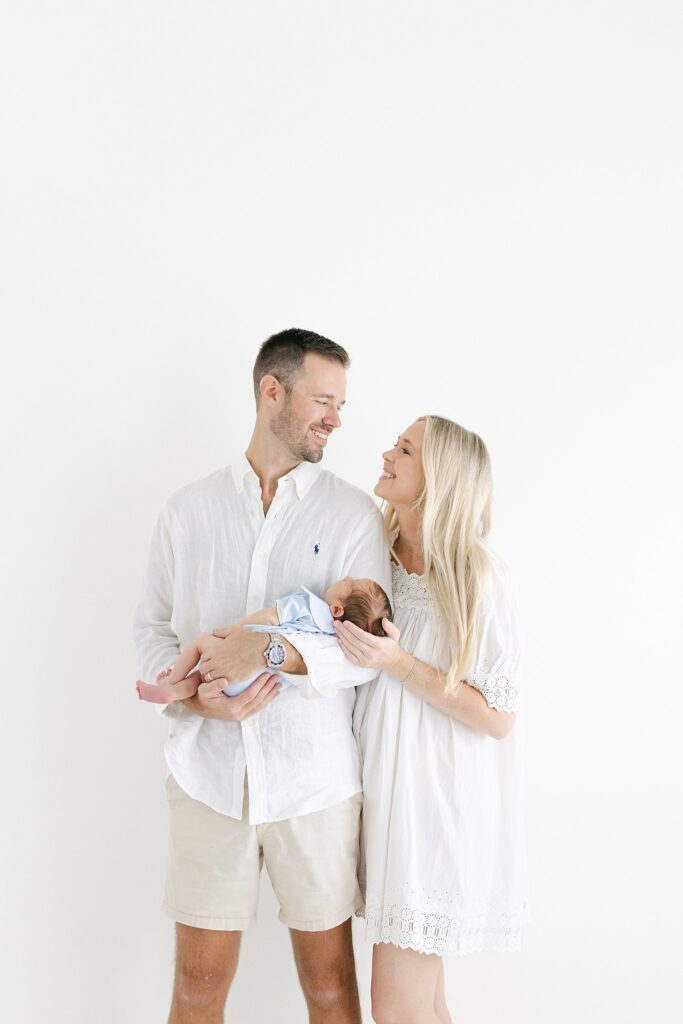 Clean, modern newborn family portrait in studio — photographed by a Jupiter, Florida newborn photographer offering heirloom artwork and styling support.