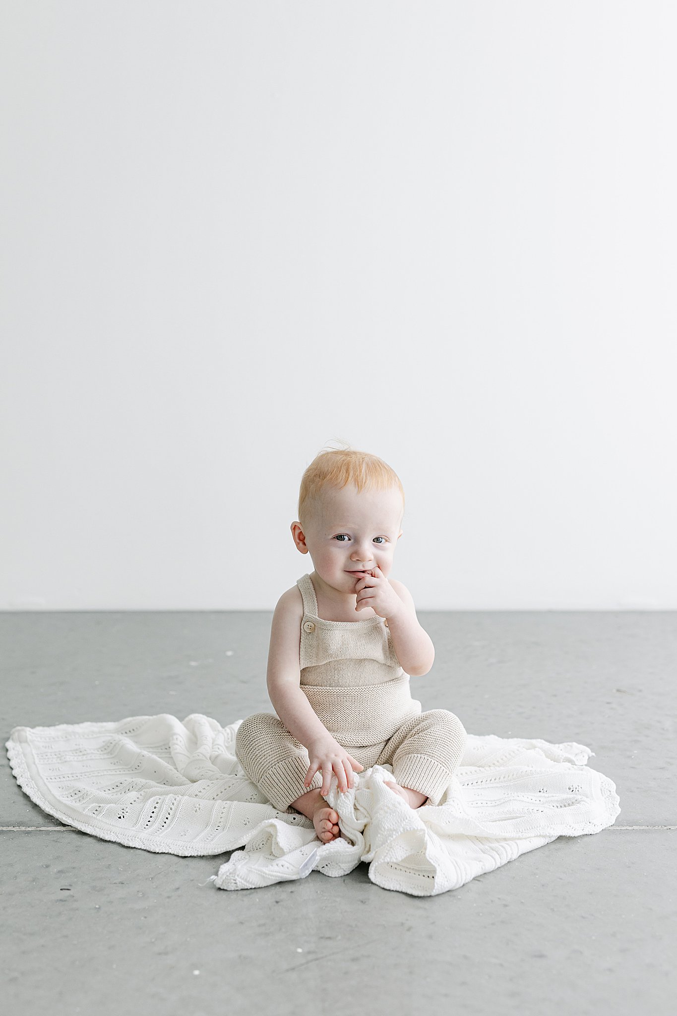 Smiling baby sitting in a white studio during a sitter milestone photography session in Port Saint Lucie.